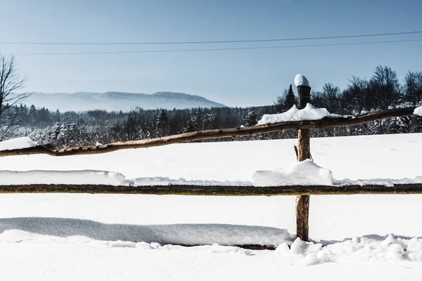 Valla de madera cubierta de nieve en las montañas de los Cárpatos - foto de stock