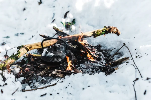 Bollitore bollente con vapore in falò nella foresta invernale — Foto stock