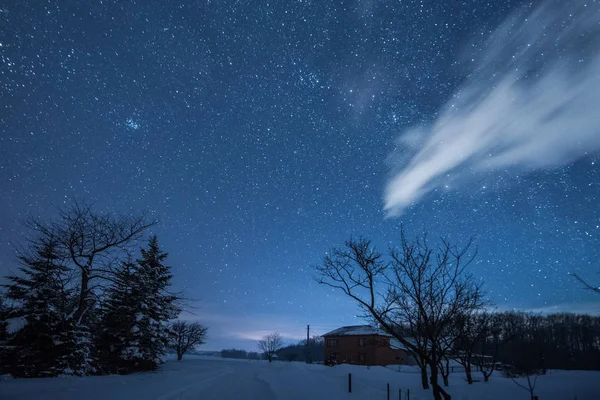 Starry dark sky and house in carpathian mountains at night in winter — Stock Photo