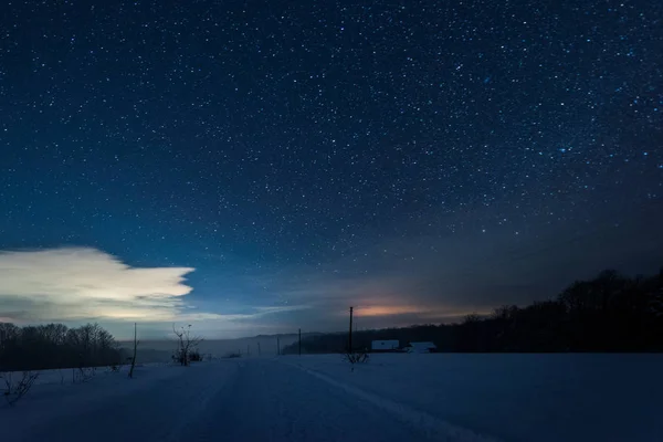 Starry dark sky and road in carpathian mountains at night in winter — Stock Photo