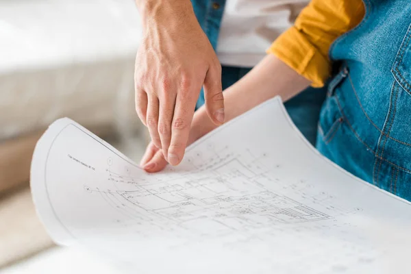 Cropped view of couple with blueprint in new home — Stock Photo