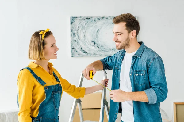 Sorrindo casal de pé perto escada e olhando um para o outro — Fotografia de Stock