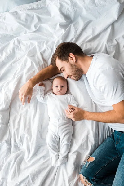 Vista superior do bebê e do pai deitado na cama — Fotografia de Stock