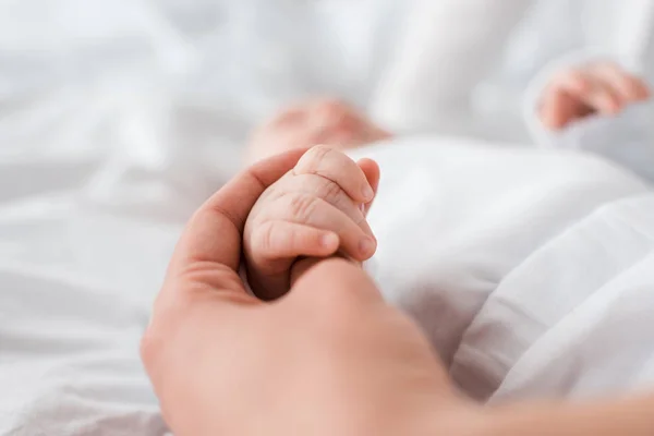 Vue recadrée de la mère et du bébé tenant la main — Photo de stock