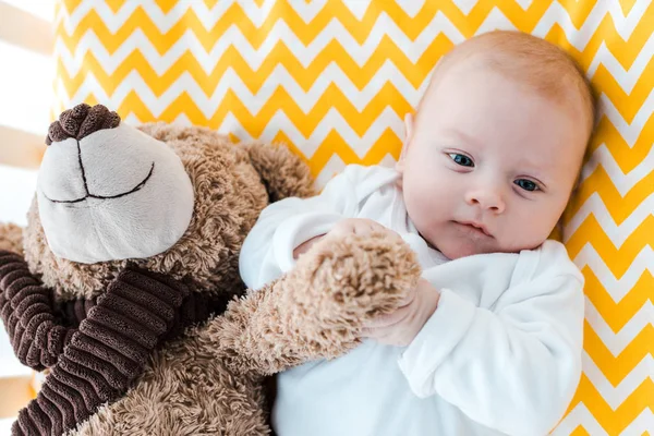 Симпатичный малыш с плюшевым медведем смотрит в камеру — стоковое фото