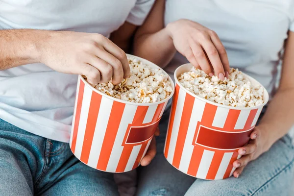 Partial view of couple in jeans with popcorn — Stock Photo