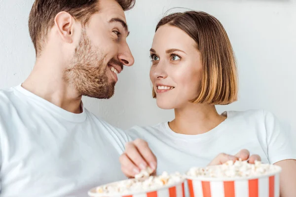 Coppia sorridente con popcorn che si guardano a casa — Foto stock