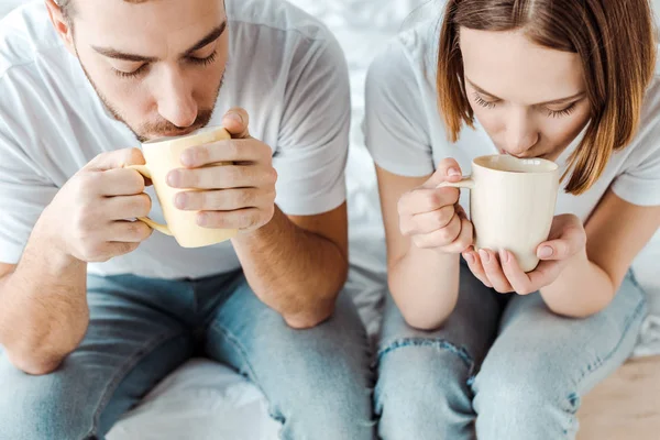 Cropped view of couple drinking coffee at home — Stock Photo