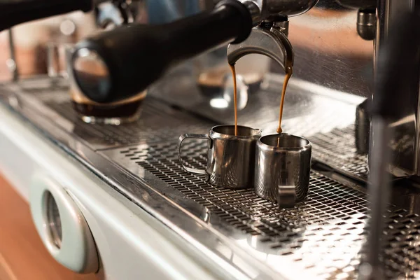 Selective focus of coffee machine and two stainless cups — Stock Photo