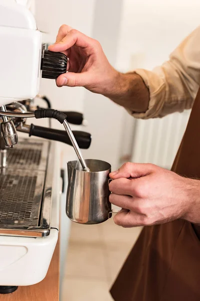 Cropped view of barista filling up steel milk jug — Stock Photo