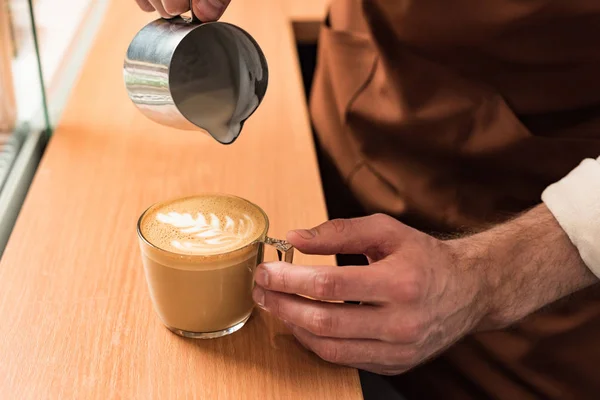 Vista cortada de barista derramando leite no café — Fotografia de Stock