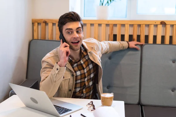 Веселий фрілансер у піджаку розмова на смартфоні в кафе — стокове фото