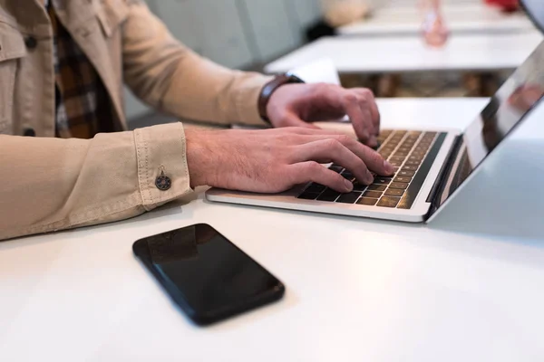 Cropped view of freelancer typing on laptop keyboard at table — Stock Photo