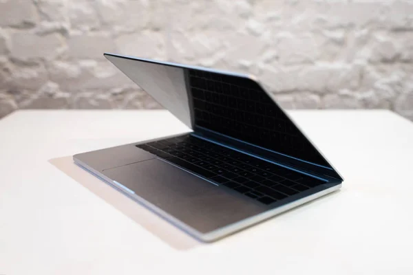 Modern laptop with blank screen on white table in cafe — Stock Photo