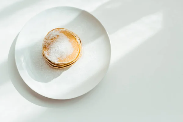 Top view of tasty pancakes with sugar powder on plate — Stock Photo