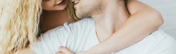 Tiro panorâmico de mulher loira abraçando namorado alegre — Fotografia de Stock