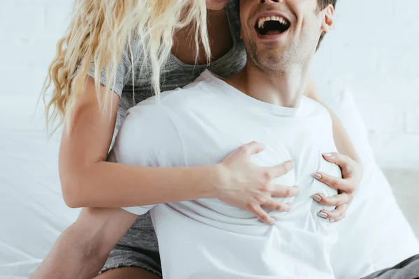 Vue recadrée de fille blonde touchant la poitrine de petit ami joyeux — Photo de stock