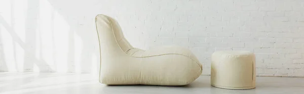 Plan panoramique de haricot sac chaise et pouf près du mur de briques dans la maison moderne — Photo de stock