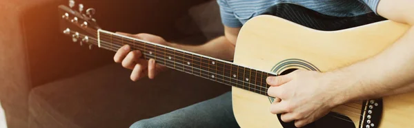 Plano panorámico del músico tocando la guitarra acústica en casa - foto de stock
