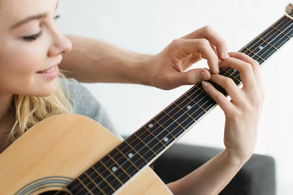 Cropped view of man and cheerful blonde woman holding hands of strings — Stock Photo