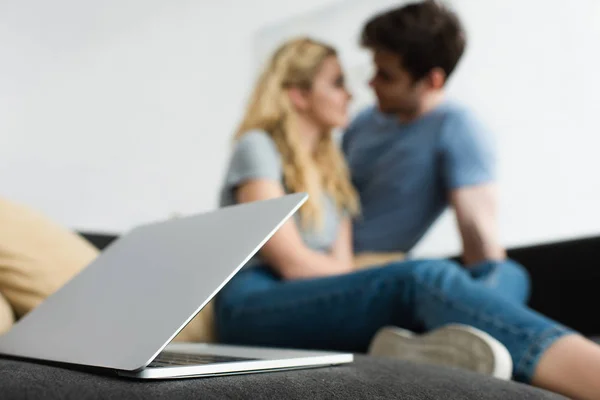 Foco seletivo de laptop perto de homem e mulher olhando um para o outro — Fotografia de Stock