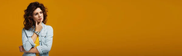 Панорамний знімок рудої жінки, яка думає, стоячи на помаранчевому — стокове фото