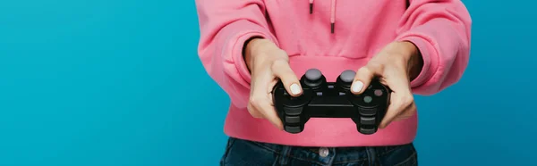 Panoramic shot of young woman holding joystick and playing on blue — Stock Photo