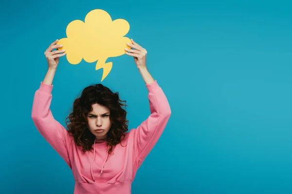 Emotional curly redhead girl holding thought bubble on blue — Stock Photo