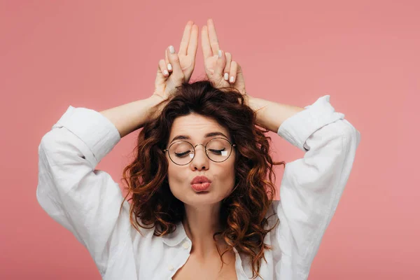 Attractive curly woman in glasses with duck face gesturing on pink — Stock Photo