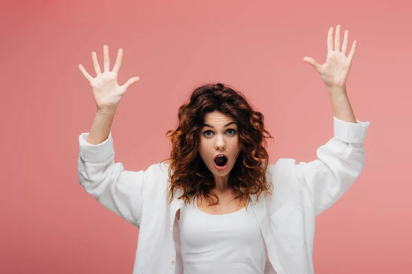 Shocked curly woman with red hair gesturing on pink — Stock Photo