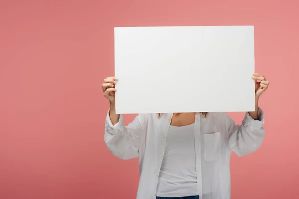 Young woman holding blank placard while standing on pink — Stock Photo