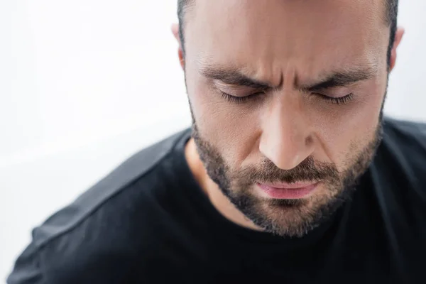 Portrait of depressed bearded man in black t-shirt standing with closed eyes — Stock Photo
