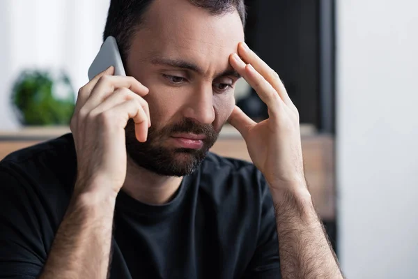 Schöner, aufgebrachter Mann mit Smartphone, der die Hand vor dem Gesicht hält — Stockfoto