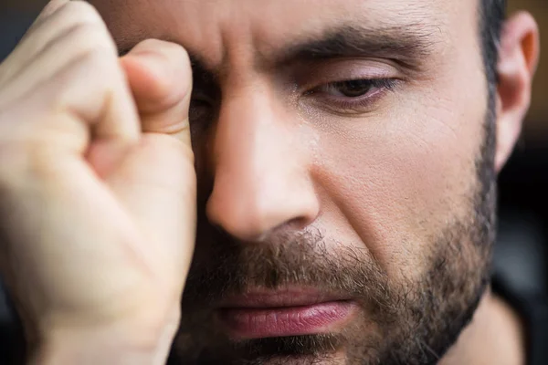 Porträt eines gut aussehenden weinenden Mannes, der Tränen mit der Hand wegwischt — Stockfoto