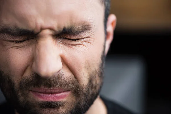 Portrait of handsome bearded man crying with closed eyes with tears on face — Stock Photo