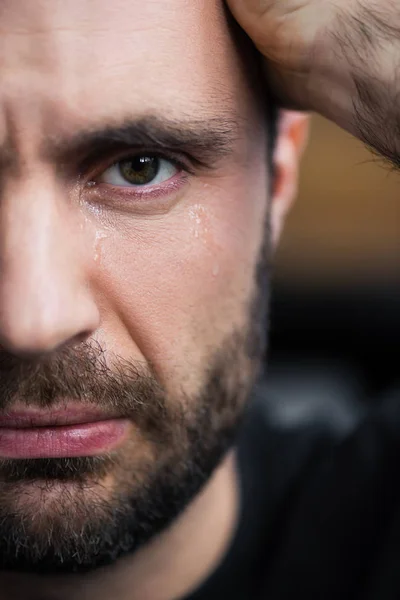 Teilbild eines weinenden Mannes mit Tränen im Gesicht, der in die Kamera blickt — Stockfoto