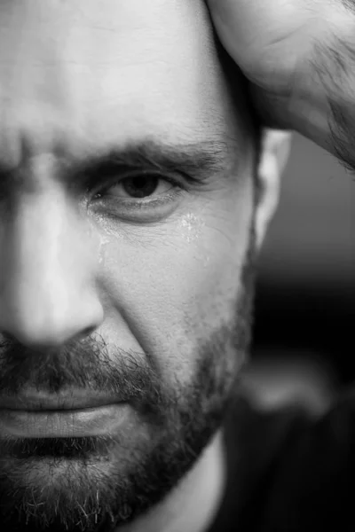 Retrato preto e branco de homem chorando barbudo olhando para a câmera — Fotografia de Stock