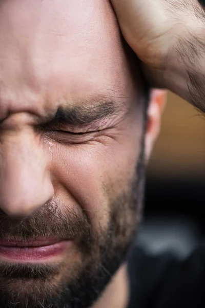 Частичный взгляд депрессивного бородатого мужчины, плачущего с закрытыми глазами — стоковое фото
