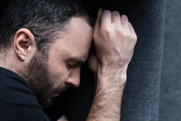 Vista dall'alto dell'uomo barbuto depresso che soffre sdraiato sul divano con gli occhi chiusi — Foto stock