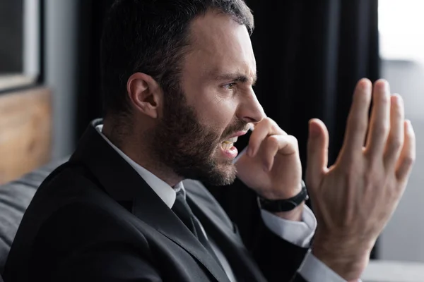 Irritato uomo d'affari urla mentre parla su smartphone in ufficio — Foto stock