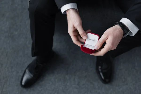 Selective focus of businessman holding red gift box with ring — Stock Photo