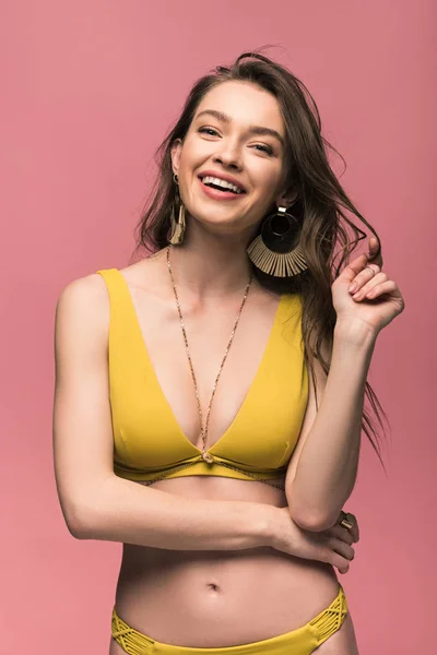 Bonita jovem mulher em maiô amarelo sorrindo isolado em rosa — Fotografia de Stock