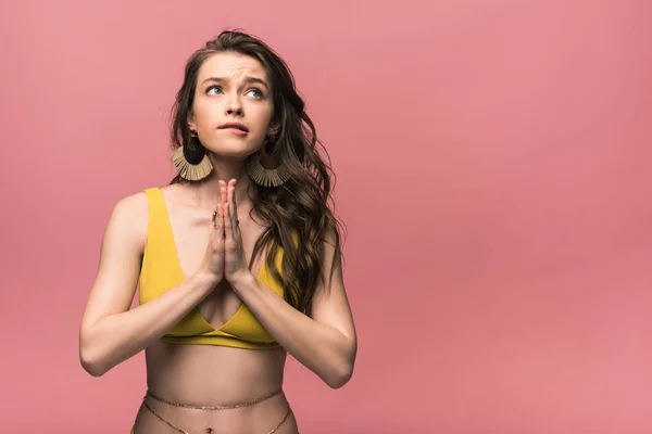 Emotionale junge Frau im gelben Badeanzug zeigt bitte Geste isoliert auf rosa — Stockfoto