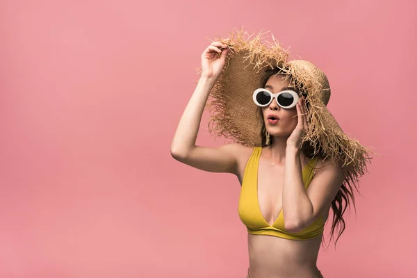 Chica sorprendida en sombrero de paja y gafas de sol aisladas en rosa - foto de stock