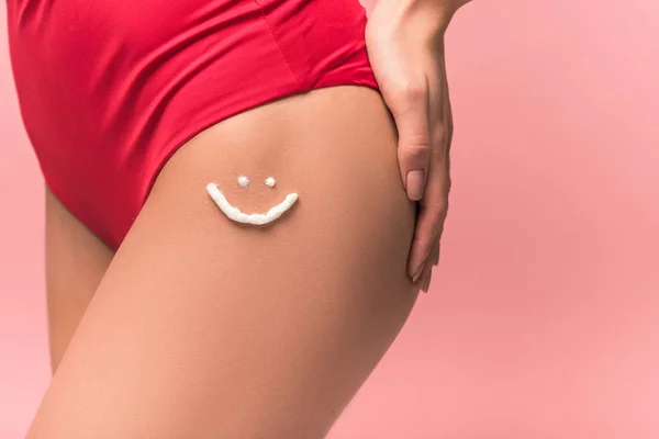Cropped view of woman with sunscreen on leg isolated on pink — Stock Photo