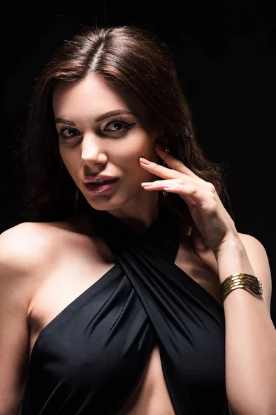 Attractive woman in swimsuit and bracelet looking at camera isolated on black — Stock Photo