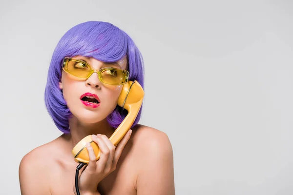 Bored woman in purple wig holding retro telephone, isolated on grey — Stock Photo