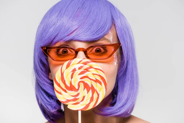 Счастливая девушка в фиолетовом парике и солнцезащитных очках, держащая леопоп, изолированная на сером — стоковое фото