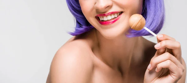 Cropped view of smiling nude girl in purple wig holding sweet lollipop, isolated on grey — Stock Photo