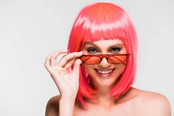 Schöne lächelnde Mädchen in rosa Perücke und Sonnenbrille isoliert auf grau — Stockfoto